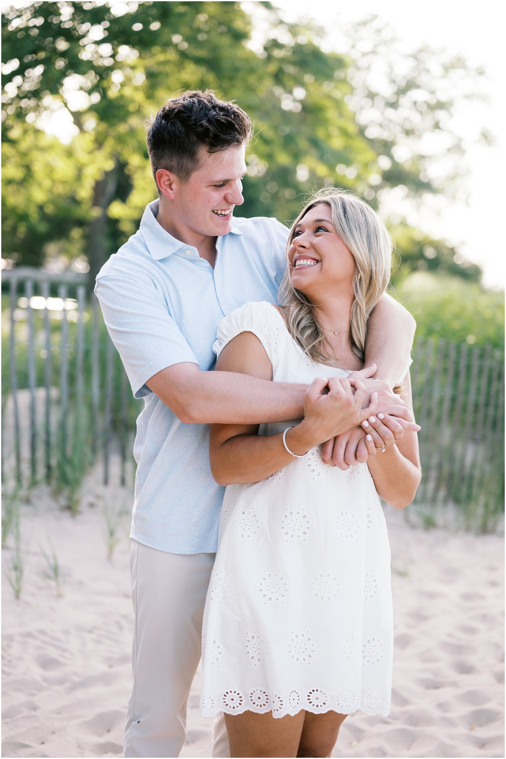 Emily & Jake’s summer engagement session at Gillson Beach in Wilmette featured beach photos, Lake Michigan views, golden hour, and a champagne pop.