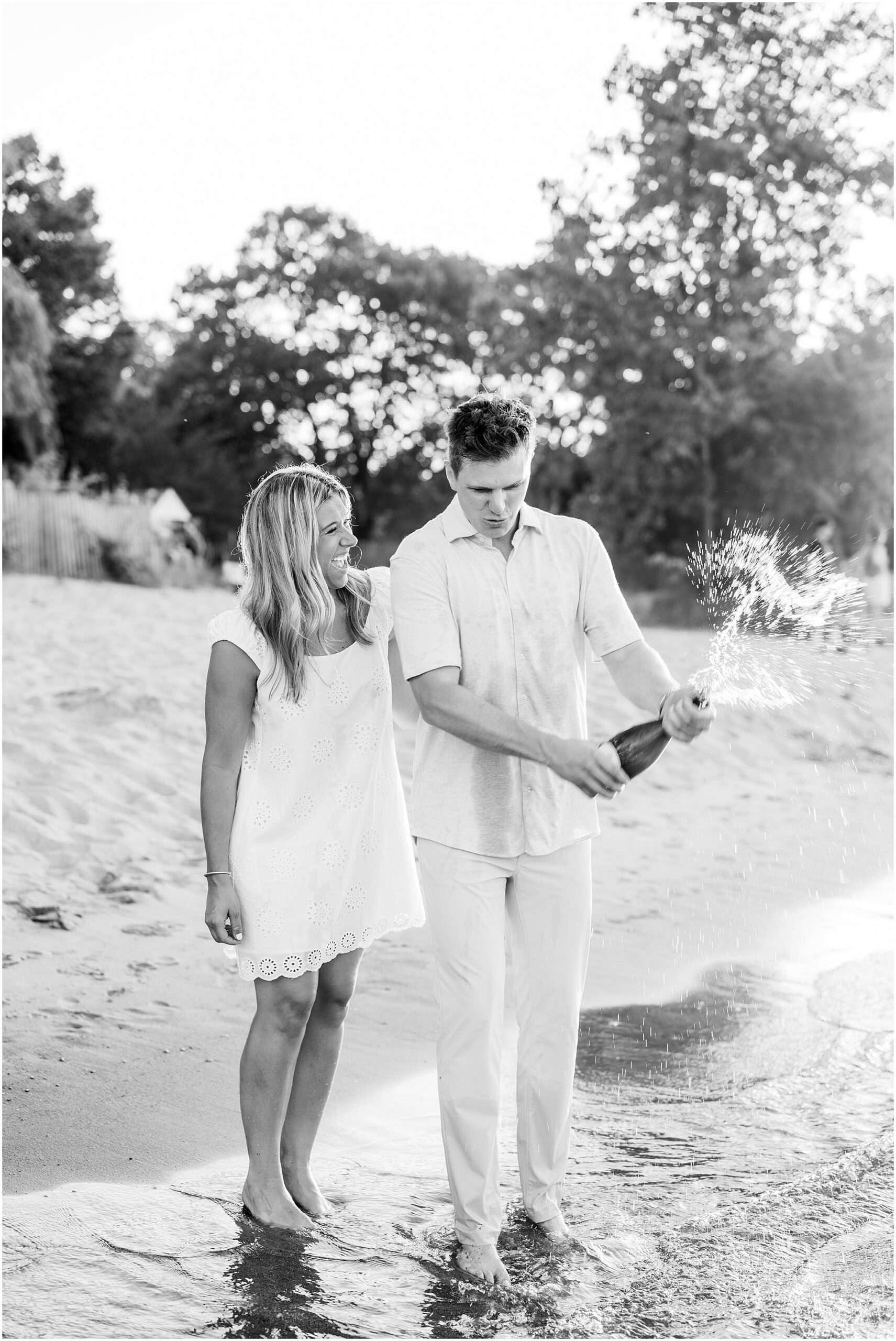 Emily & Jake’s summer engagement session at Gillson Beach in Wilmette featured beach photos, Lake Michigan views, golden hour, and a champagne pop.