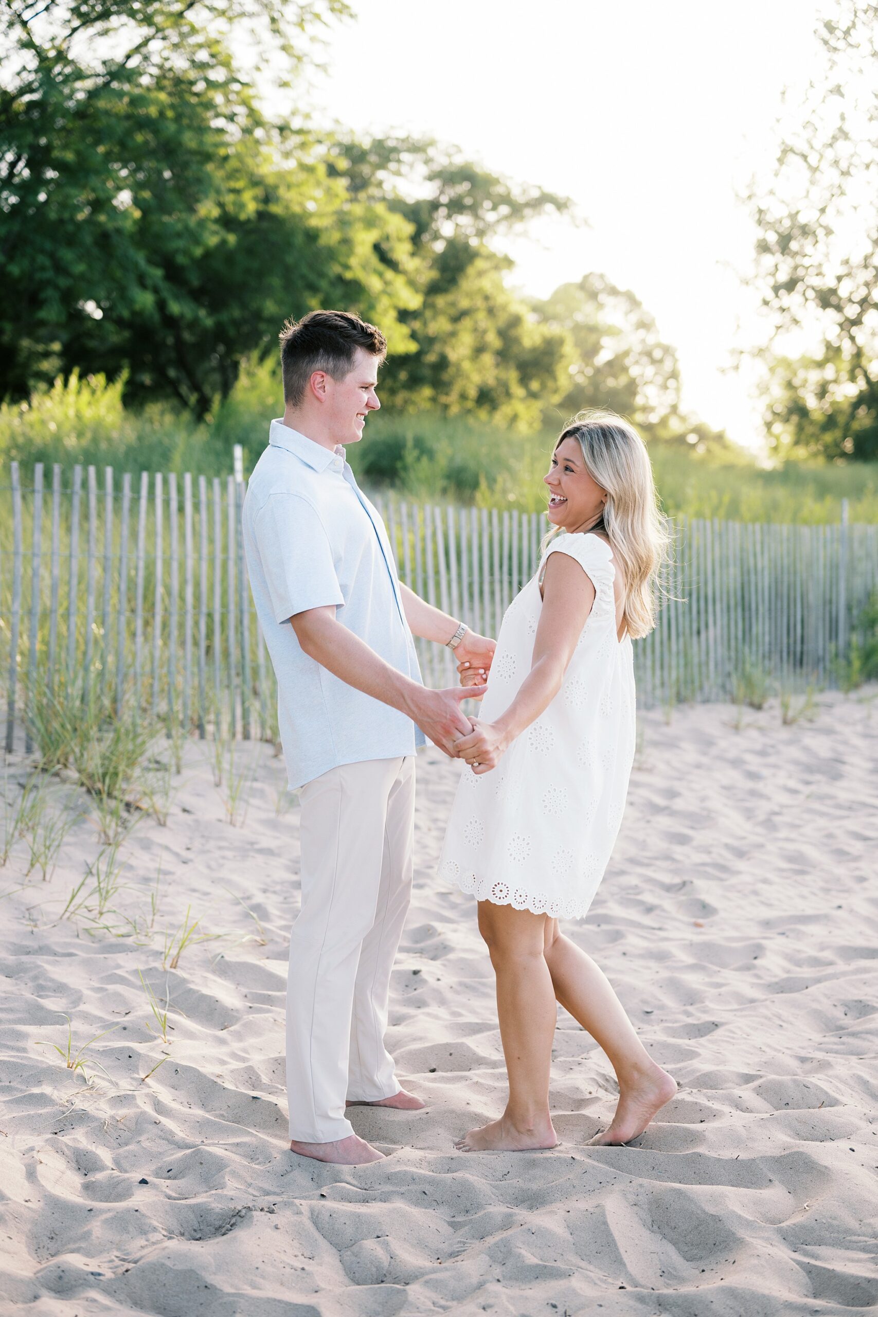 Emily & Jake’s summer engagement session at Gillson Beach in Wilmette featured beach photos, Lake Michigan views, golden hour, and a champagne pop.